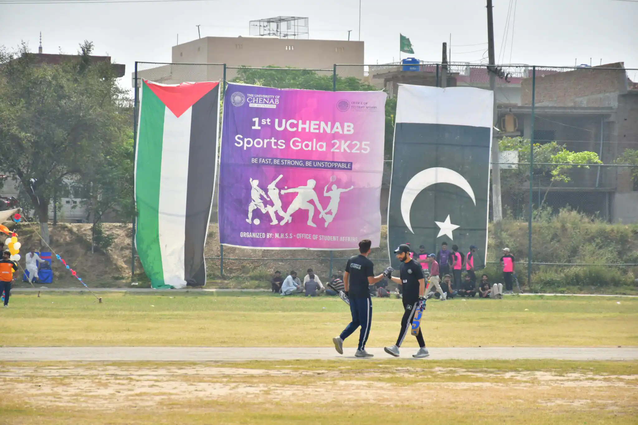 University playground with open sports field and campus surroundings.